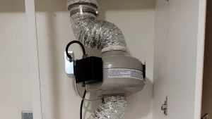 Dryer booster fan in cupboard