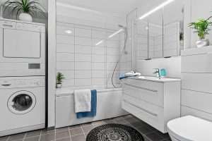 Modern strata laundry area with stacked washer and dryer, representing clean indoor air systems and winter duct maintenance in Vancouver.