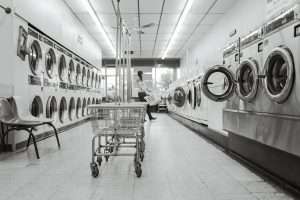 Rows of commercial dryers in a strata laundry room requiring dryer vent cleaning in Surrey